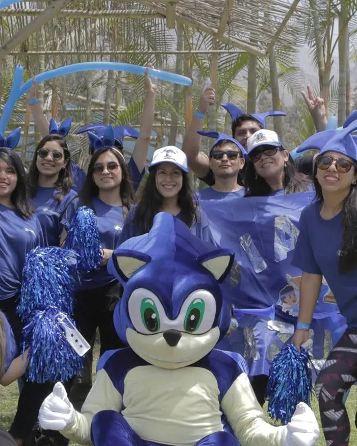 Un grupo numeroso levanta los brazos y celebra al final de una jornada de integración al aire libre